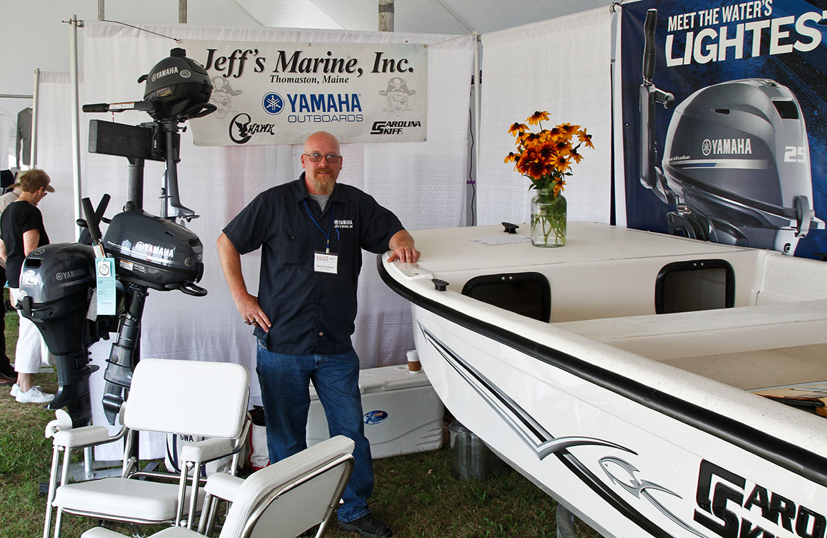 Exhibitor standing near a boat display