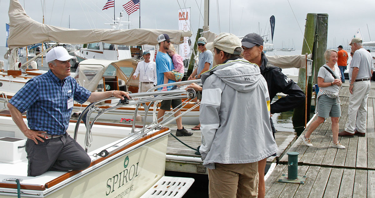 Exhibitor speaking with visitors inside a show tent