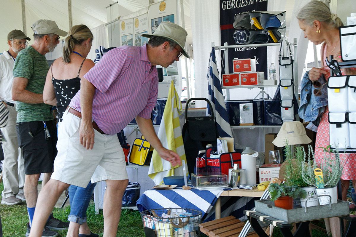 Visitors browsing exhibitor products inside a show tent