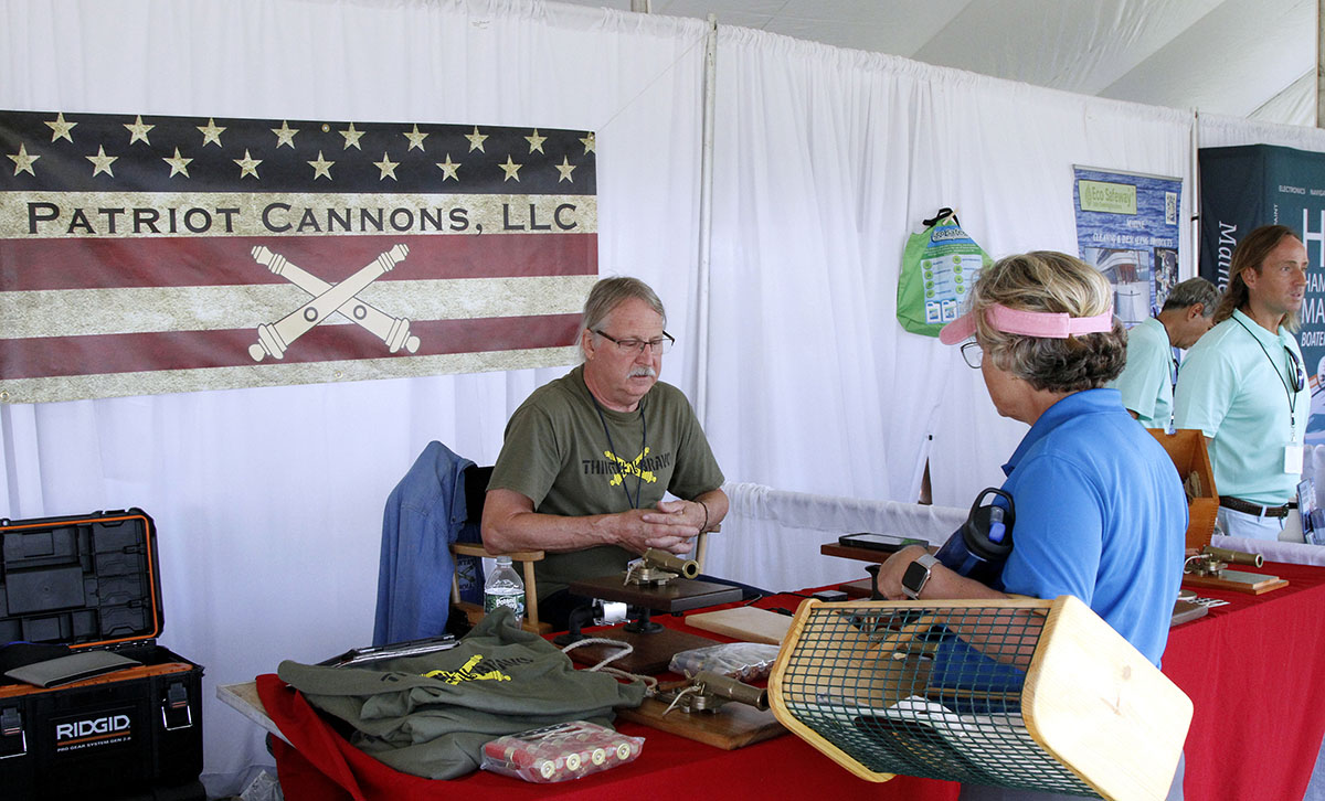 Exhibitor speaking with visitors inside a show tent