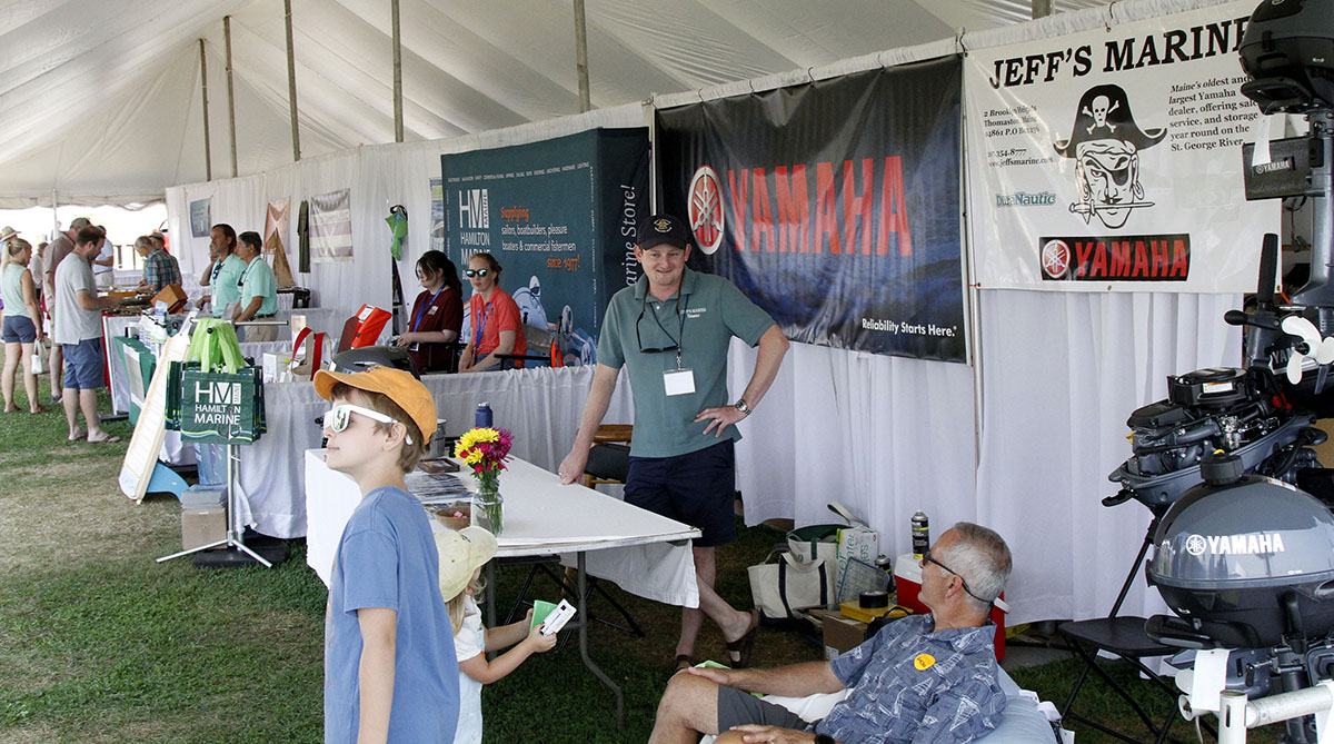 Exhibitor tent with visitors and marine displays
