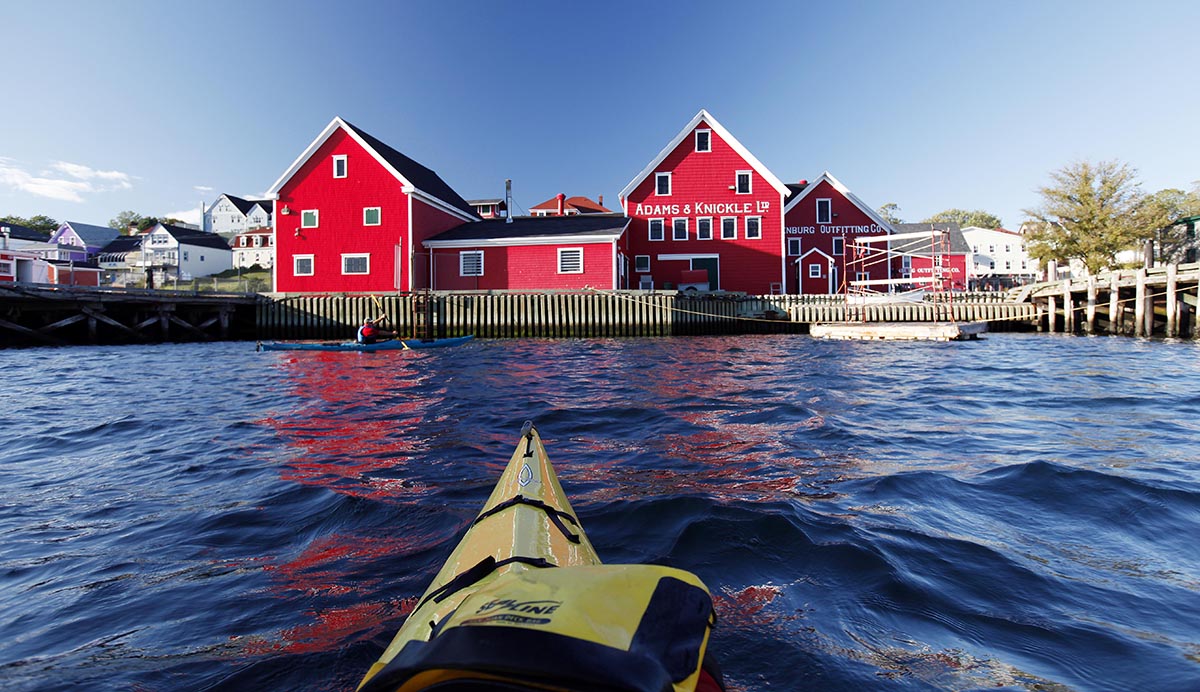 A kayak approaches Adams & Knickle, a fishing company in Lunenburg. Once known as an exporter of salt fish,. the company today is known for its deep-sea scallops.